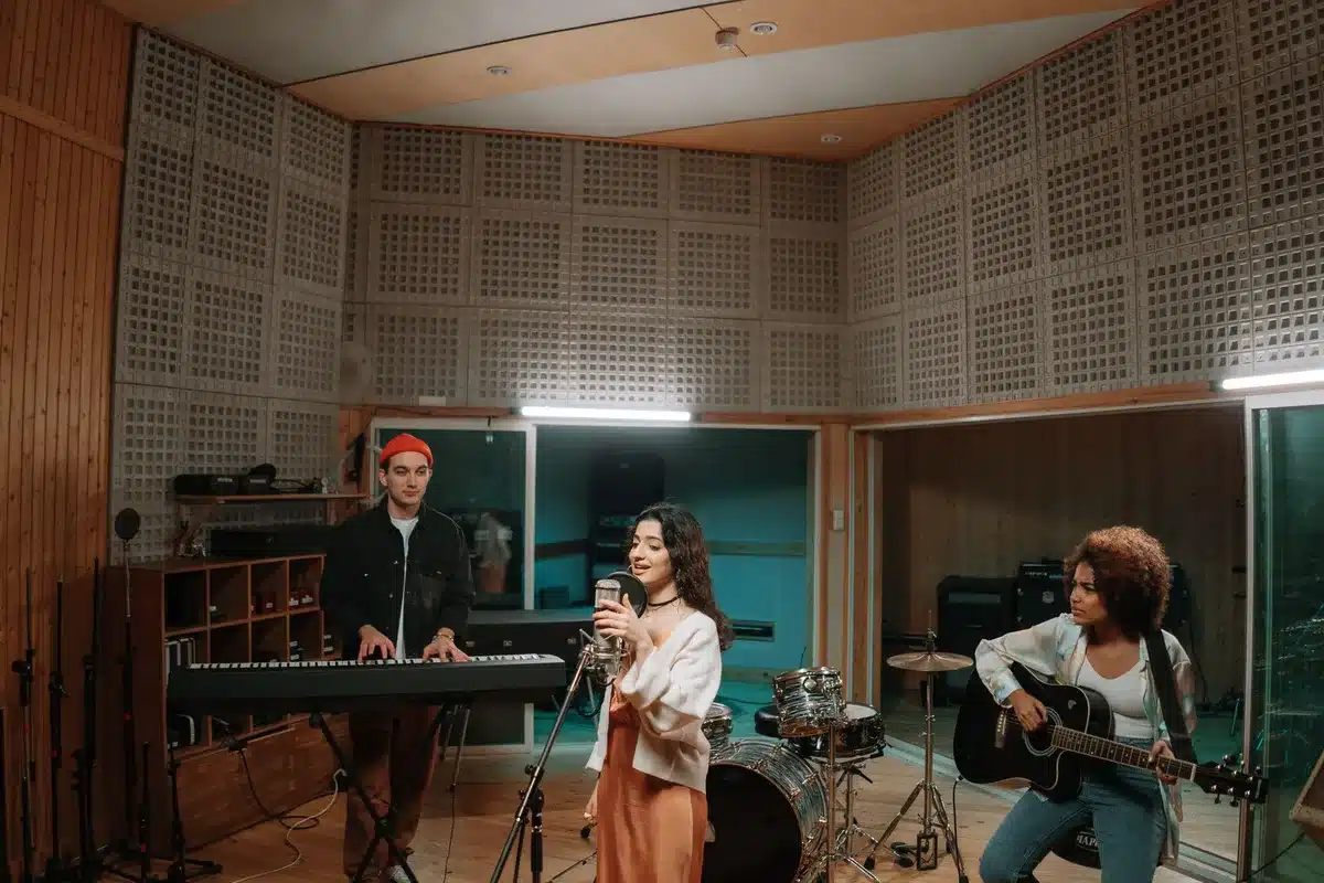 Musicians playing instruments in a recording studio with moody lighting