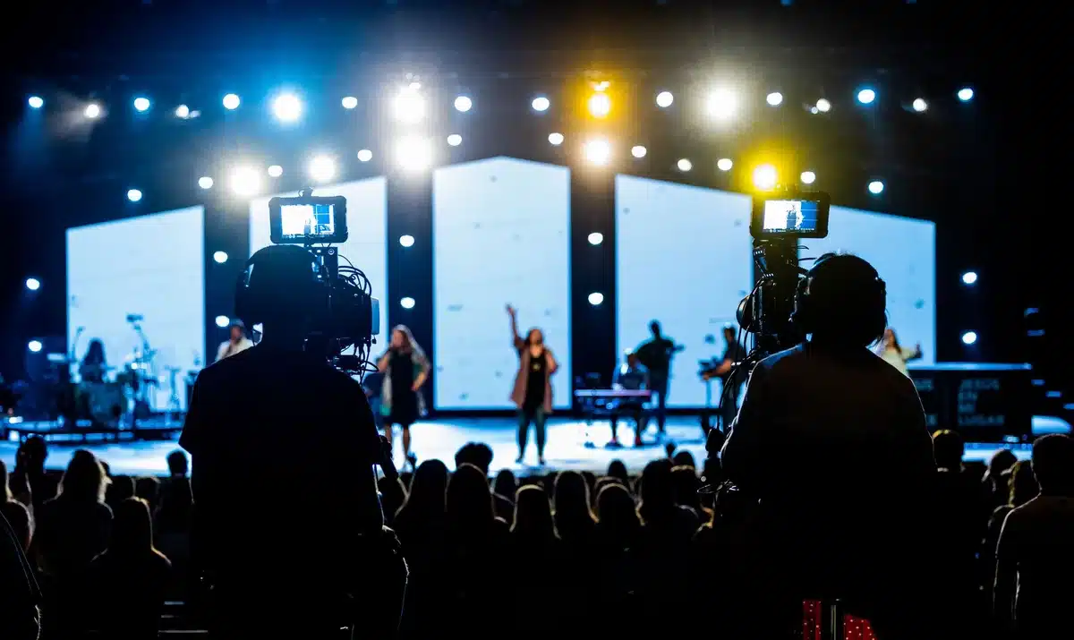 Band performing on stage with dramatic lighting during music video shoot