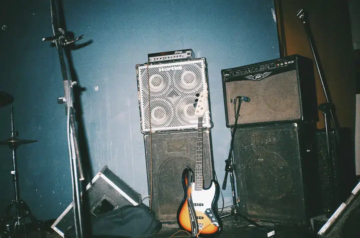 Gitarrist spielt auf einer elektrischen Gitarre mit leuchtender Verstärkeranlage im Hintergrund