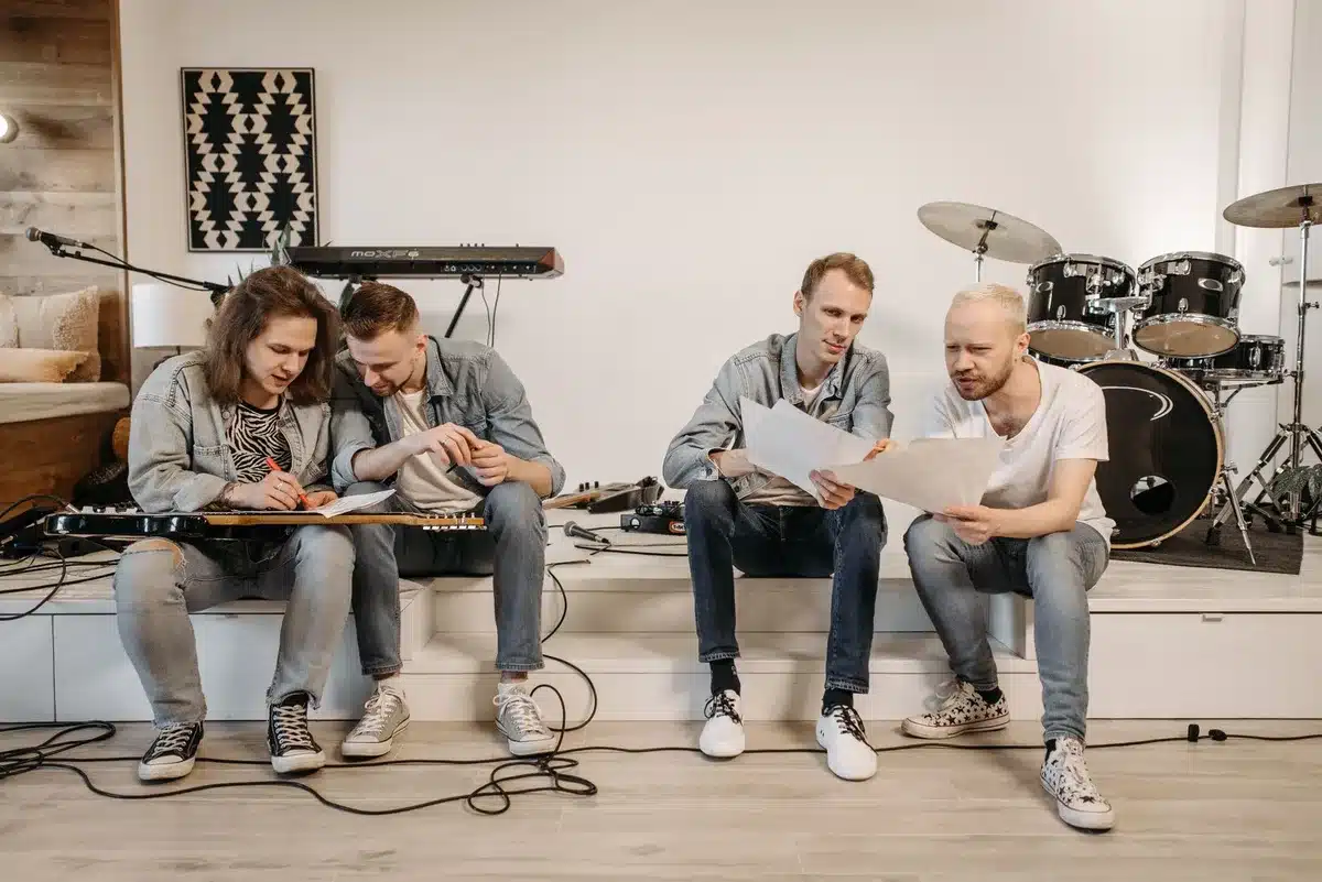 Anggota band bekerja bersama di studio rekaman dengan instrumen dan peralatan profesional