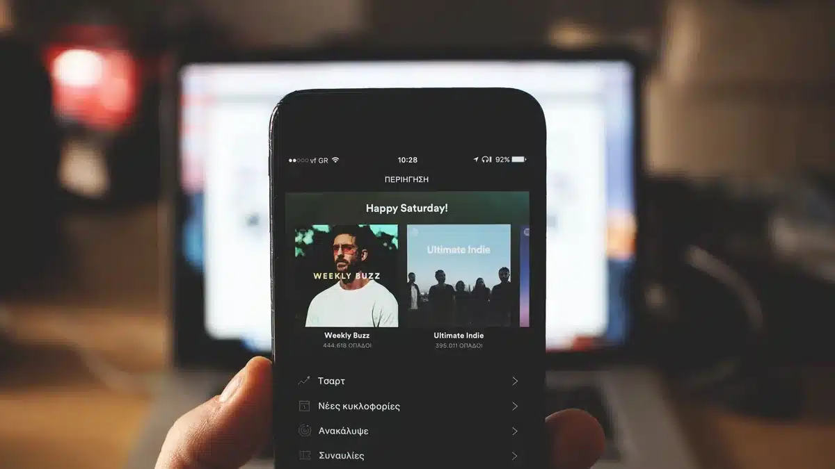Person scrolling through music streaming playlists on a smartphone