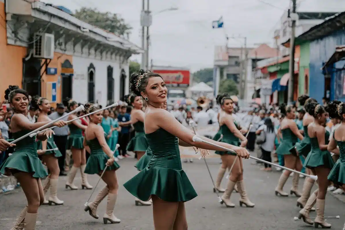 A dance group performing an impromptu routine on a public street with passersby watching and reacting