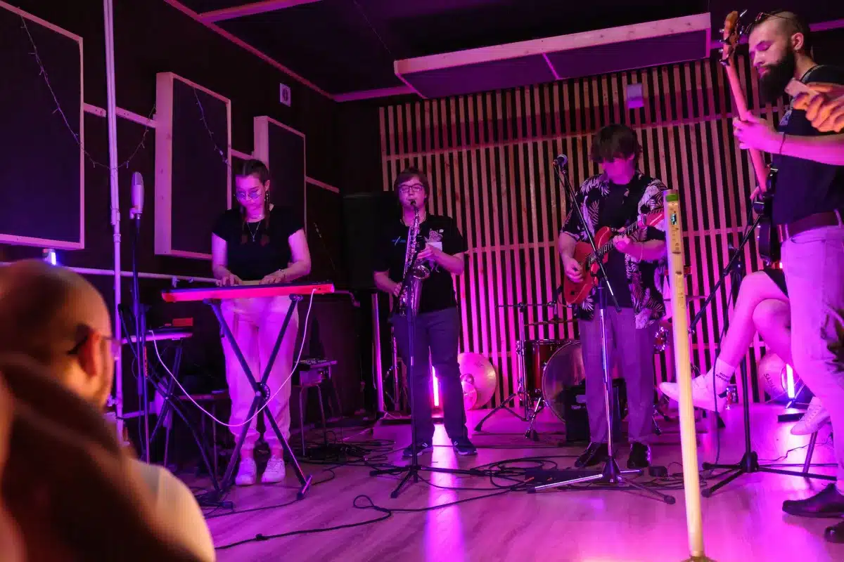 Musicians performing with acoustic instruments on a small intimate stage