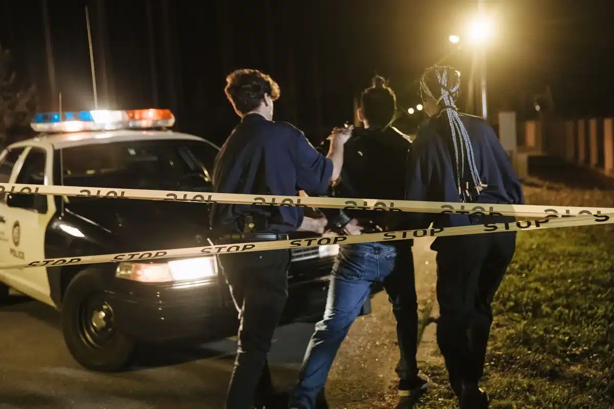 Police vehicles and officers during a late-night arrest operation on a Dallas street