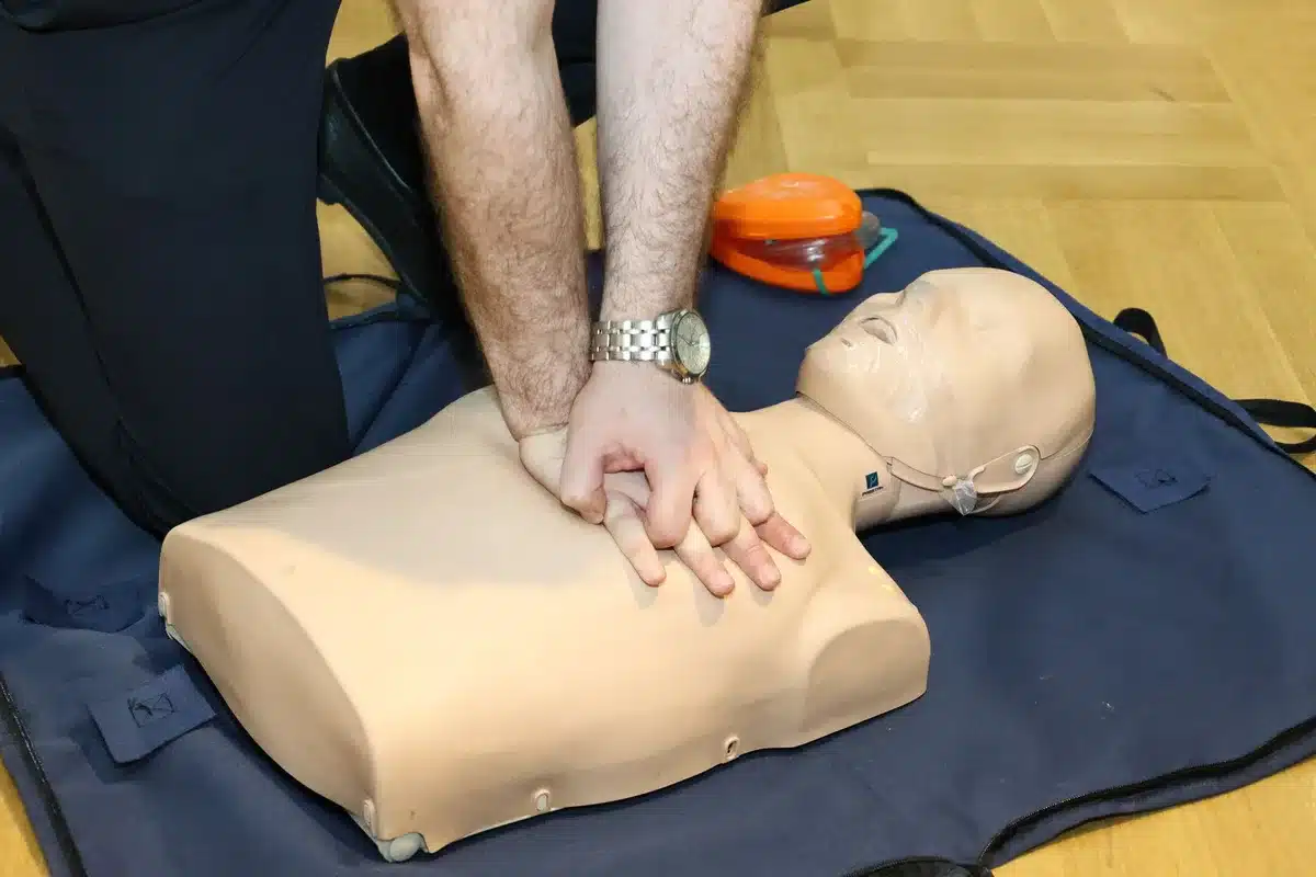 Demonstrasi kompresi dada pada boneka CPR dengan penekanan yang benar di pusat dada