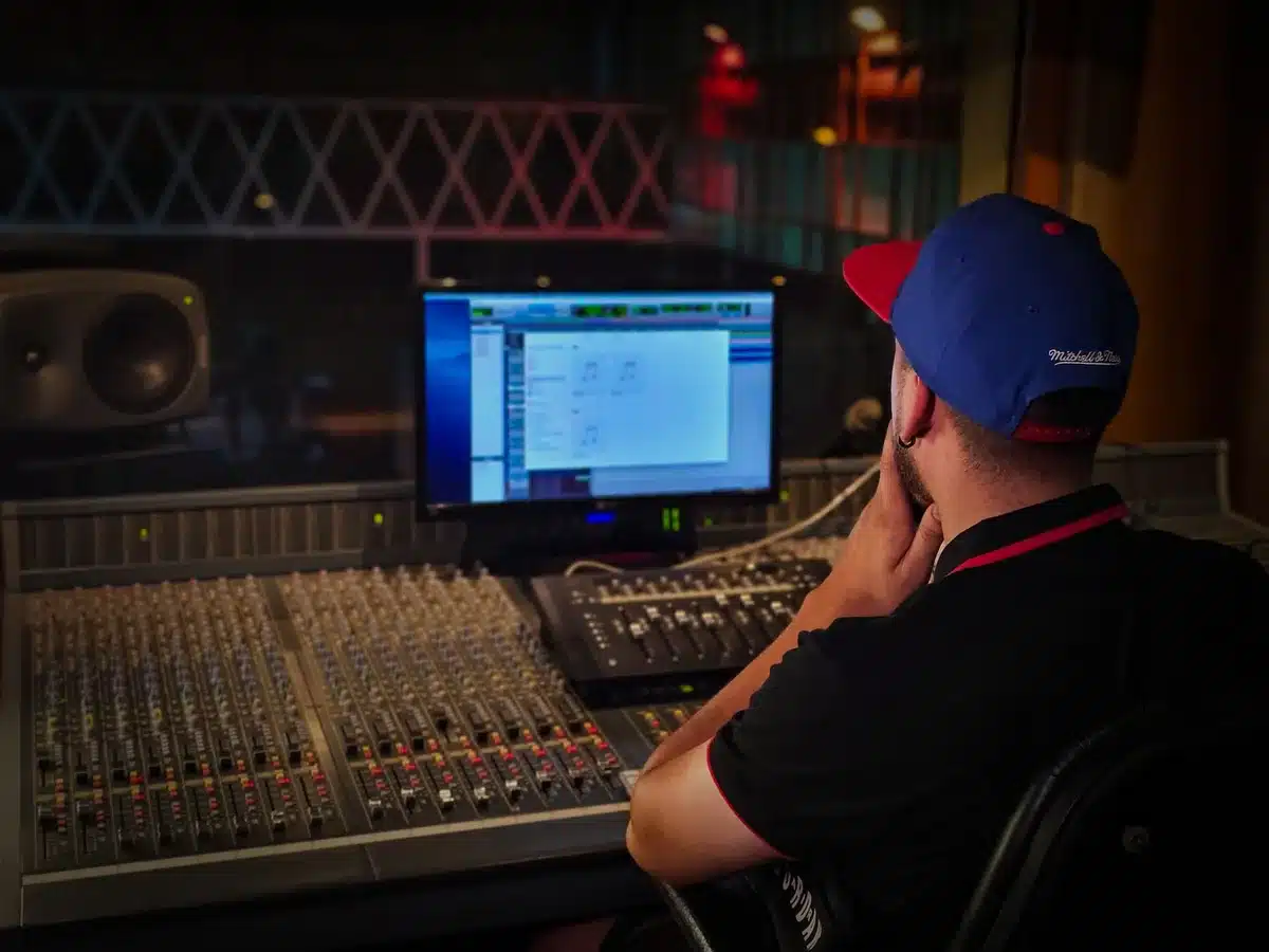 Producer working on a hip-hop track in a recording studio with equipment