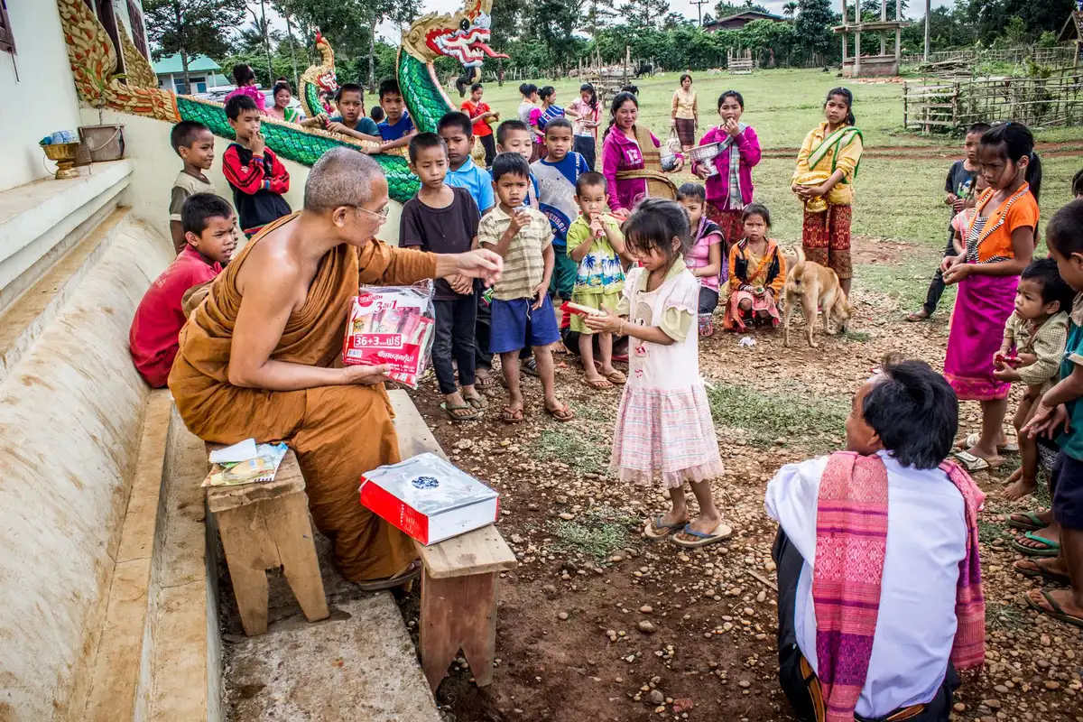 Hands offering books or educational materials in a community setting