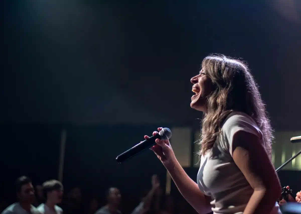 Singer performing on stage with animated energy and crowd interaction