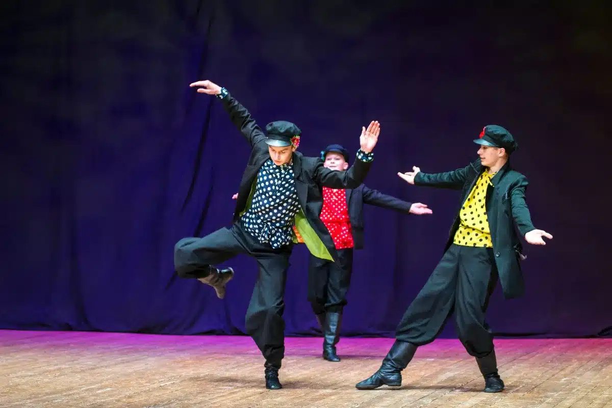 Dancers performing synchronized choreography in formation on a music video set