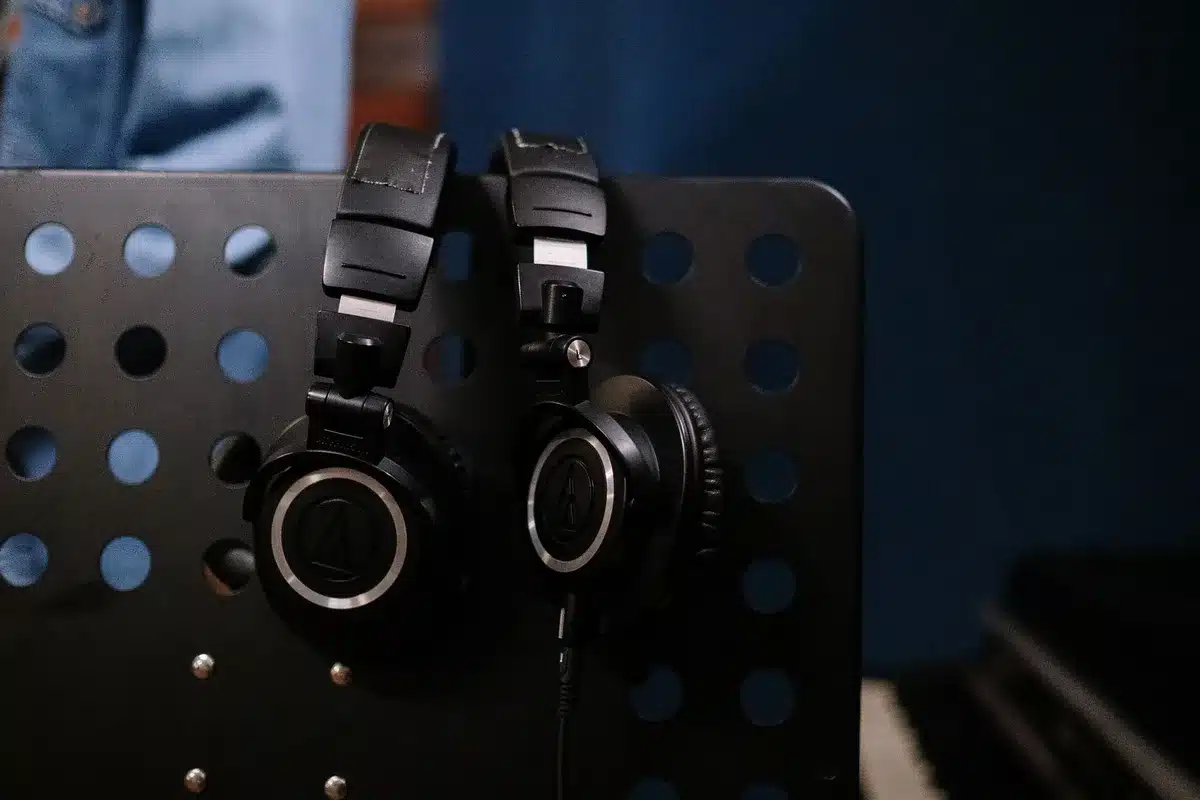 Headphones and production equipment in a dimly lit recording studio setup