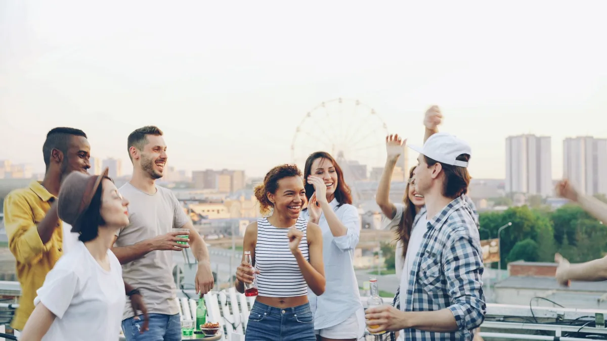 Group of people gathered on a rooftop or outdoor space in the evening
