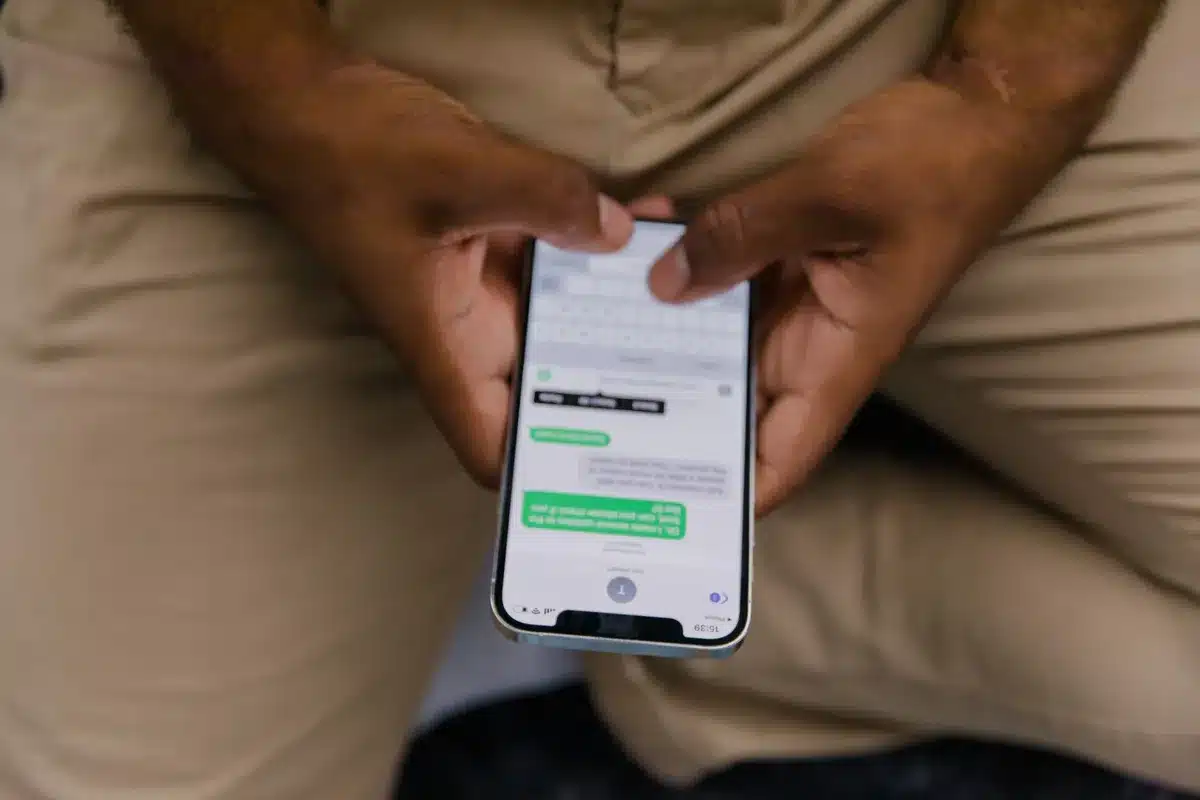 Close-up of hands typing a message on a smartphone screen