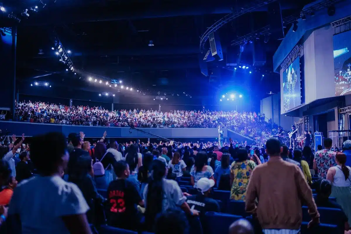 Packed arena with stage lights and crowd during a live performance