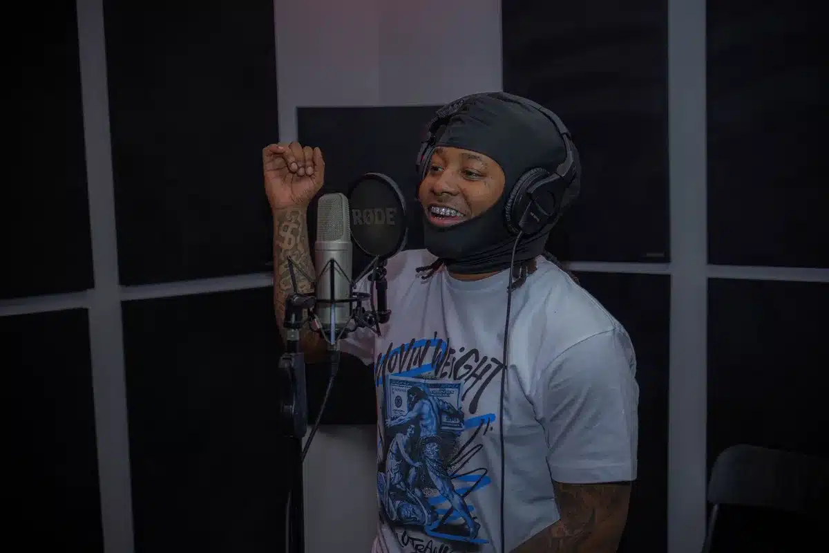 Artists collaborating in a recording studio during a hip-hop production session