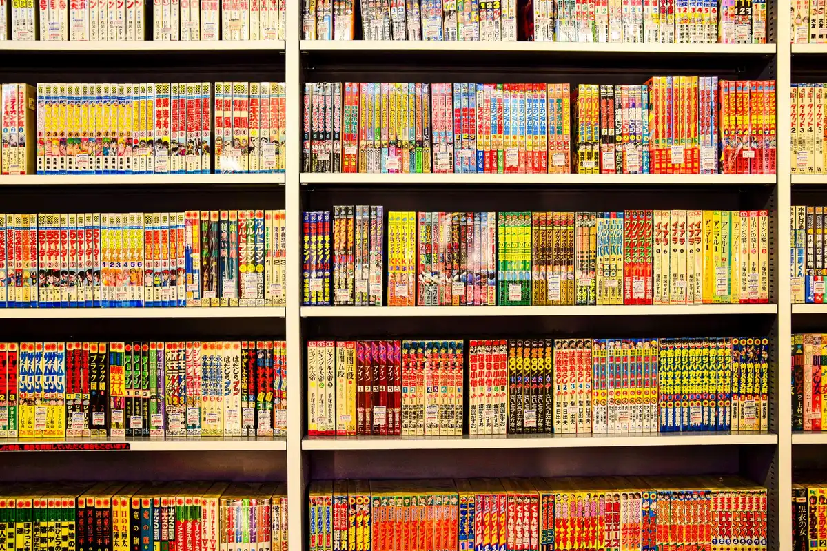 Shelves displaying manga and graphic novels in a bookstore, with colorful spines and illustrated covers.