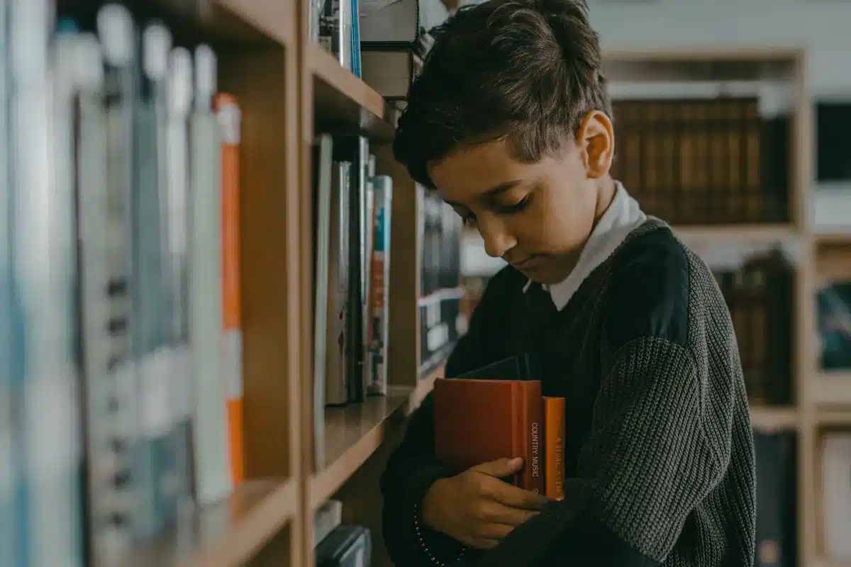 A young reader looking concentrated while holding a thick chapter book, showing the challenge of longer novels.