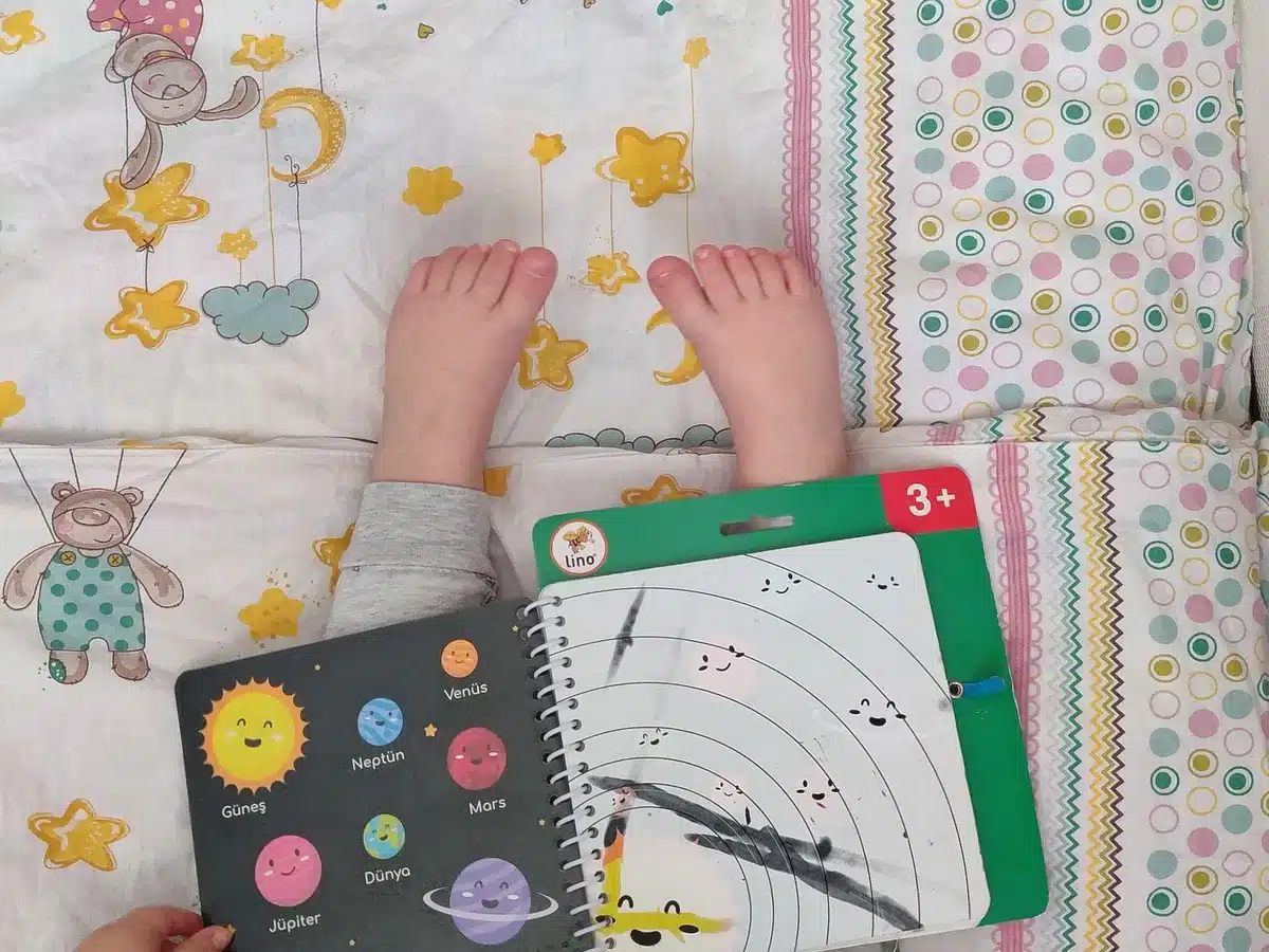 Child's hands holding and reading a colorful illustrated graphic novel with vibrant panels and artwork.
