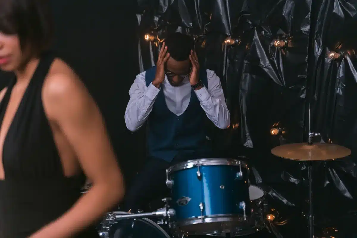 Drummer performing intensely on stage, expressing raw emotion during a live show.