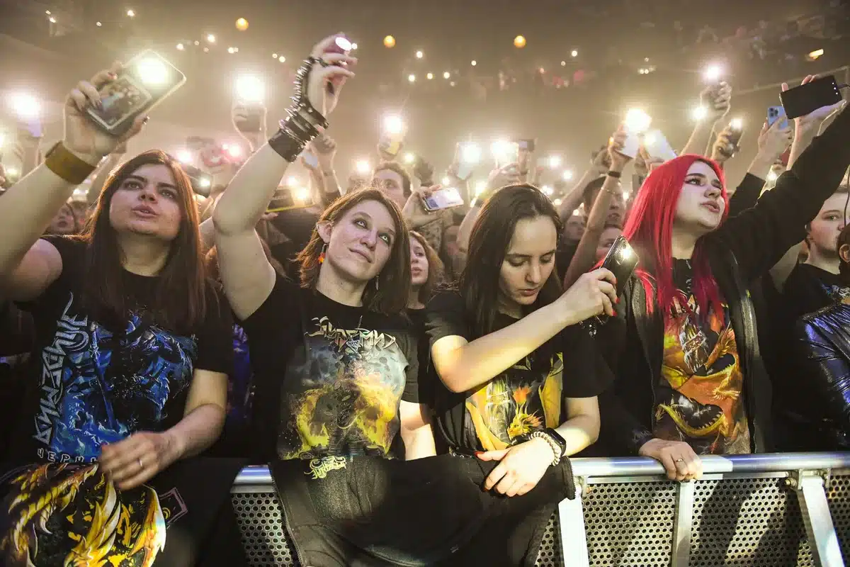 Metal fans in a crowd at a concert, showing varied reactions and engagement.
