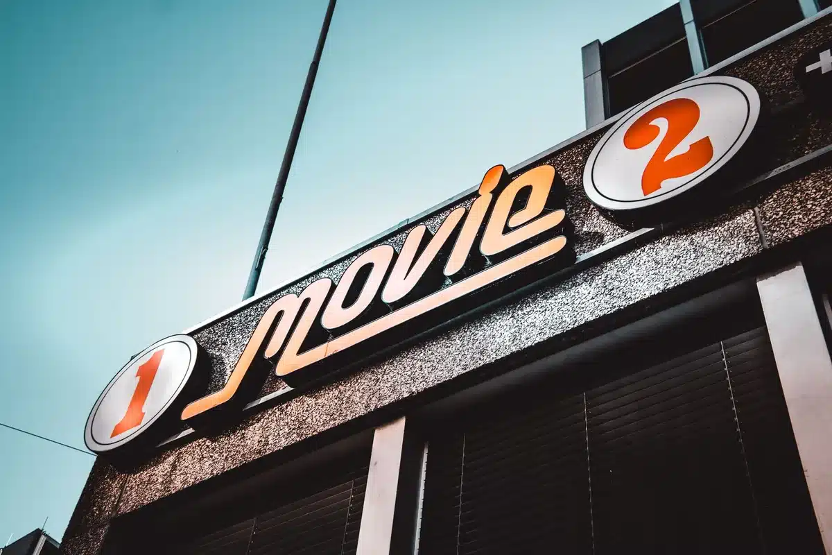 Illuminated cinema marquee displaying multiple blockbuster film titles