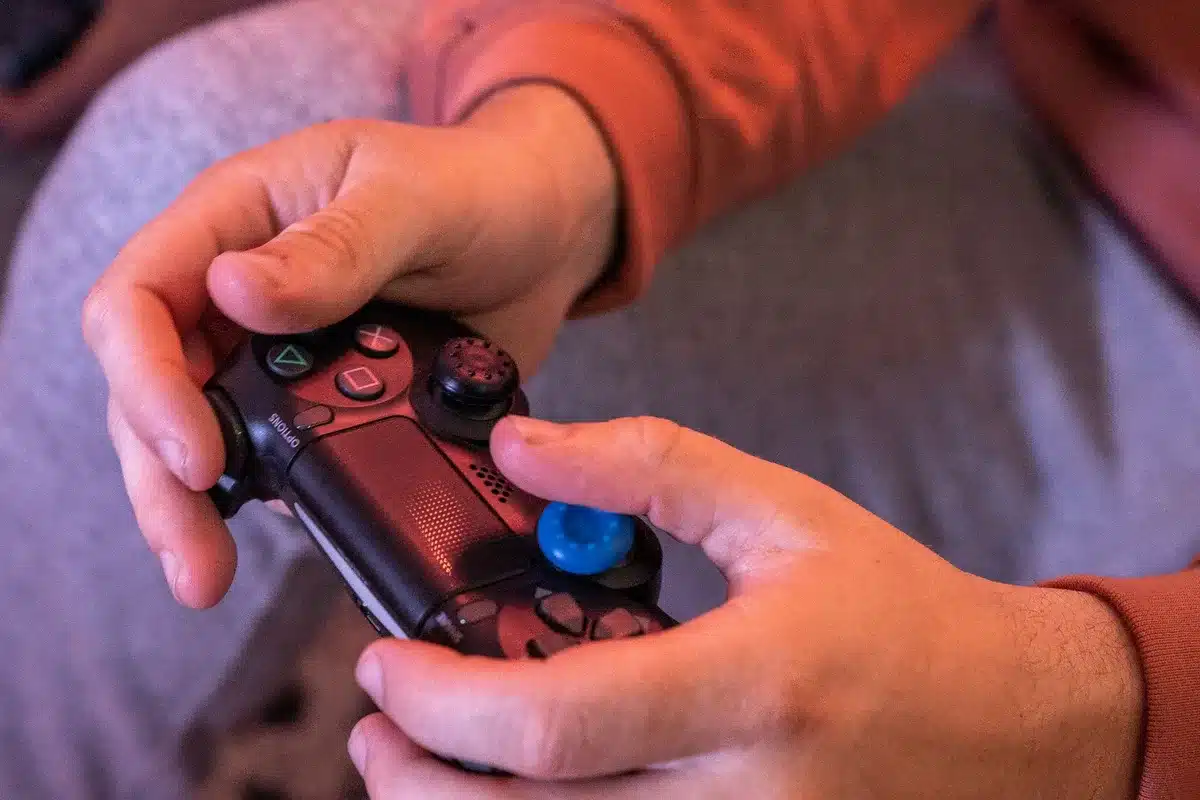 Hände spielen auf einem Gaming-Controller mit fokussiertem Blick