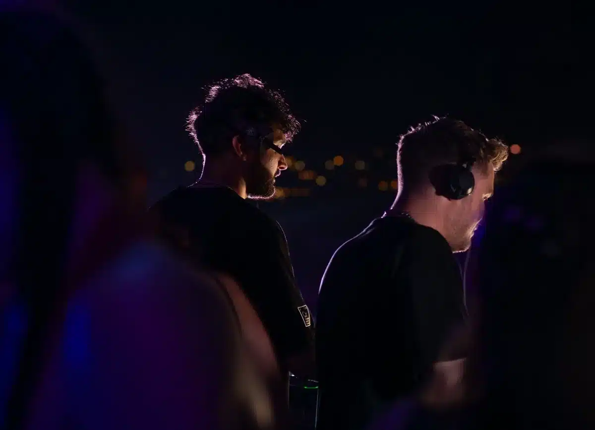 Person wearing headphones at a DJ setup with electronic equipment