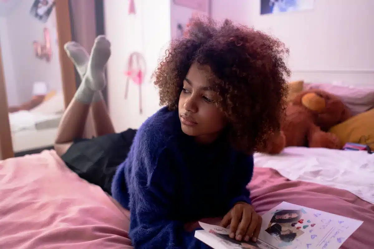 Person writing in a journal in a bedroom, capturing raw personal emotions and confessional moments.