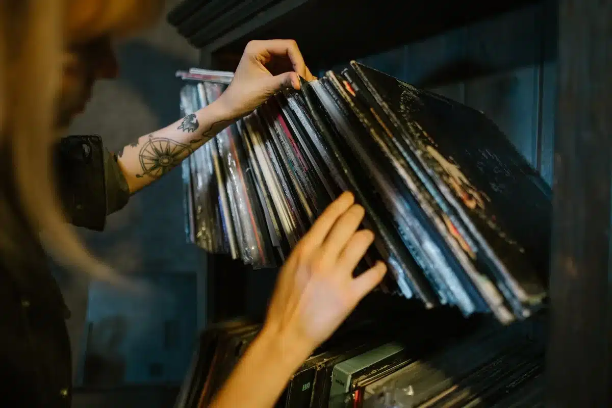 Person focused on listening to vinyl records with headphones
