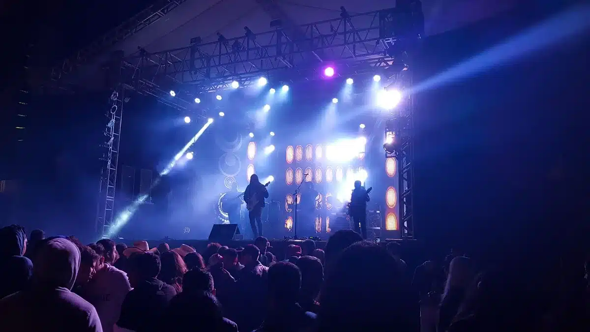 Empty concert stage with darkened lights and silent arena seating