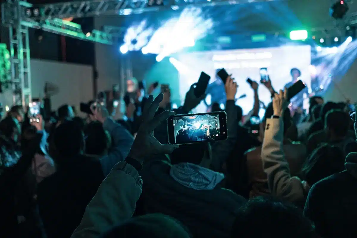 Audience members holding phones to record live music performance