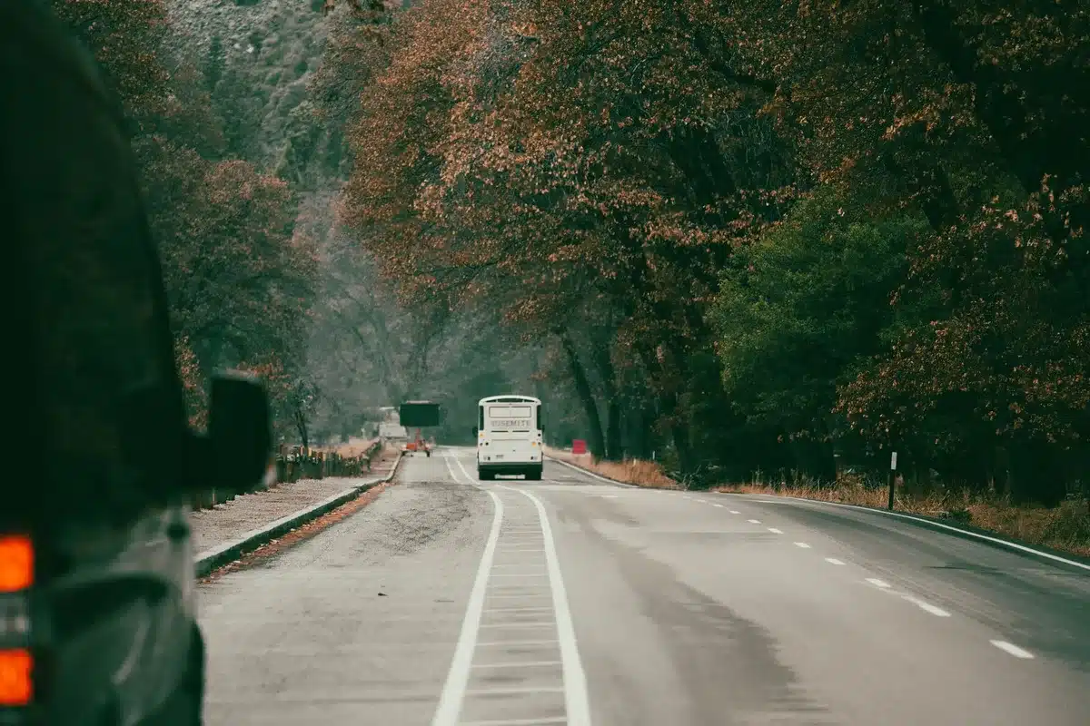 A tour bus traveling on a multi-lane highway at night, illustrating long-distance touring conditions.