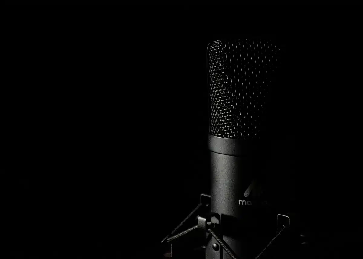 Podcaster speaking into microphone in a professional recording studio setup