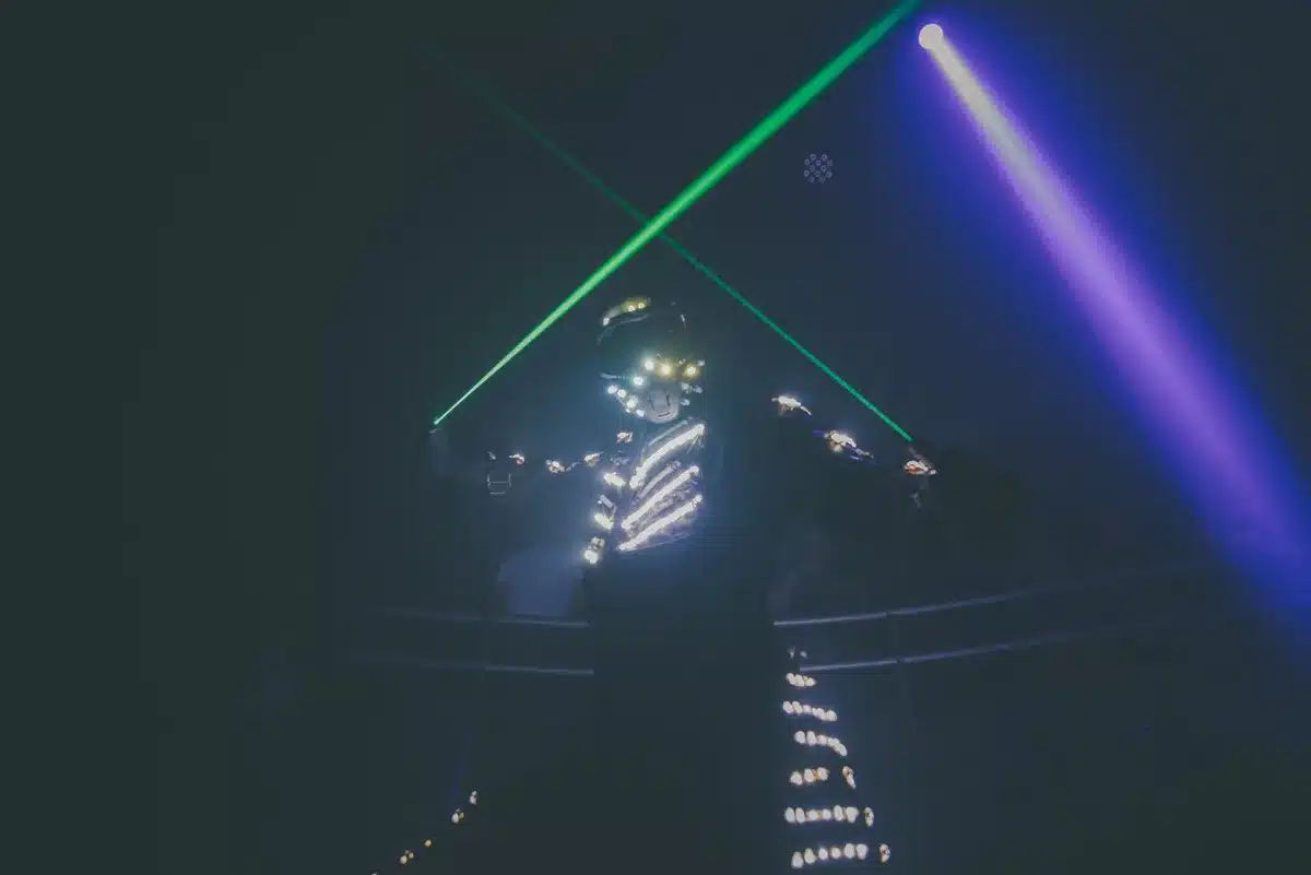 Anonymous dancers with raised hands in a dimly lit club with strobing lights