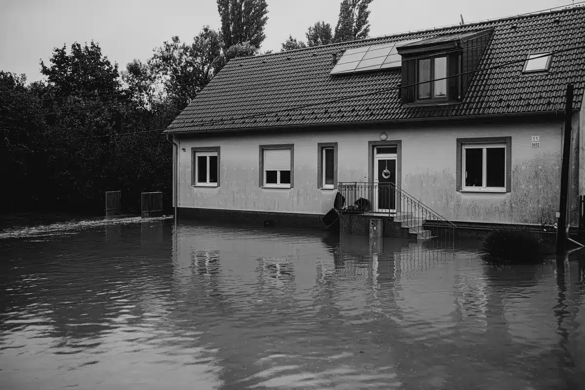 Haus mit überfluteten Fenstern und Regenwasser, das gegen die Scheiben drückt
