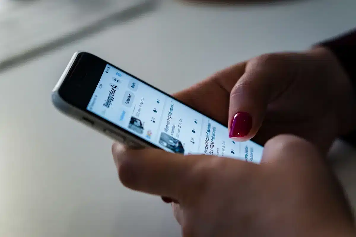 Person scrolling through social media feed with news and fact-check alerts
