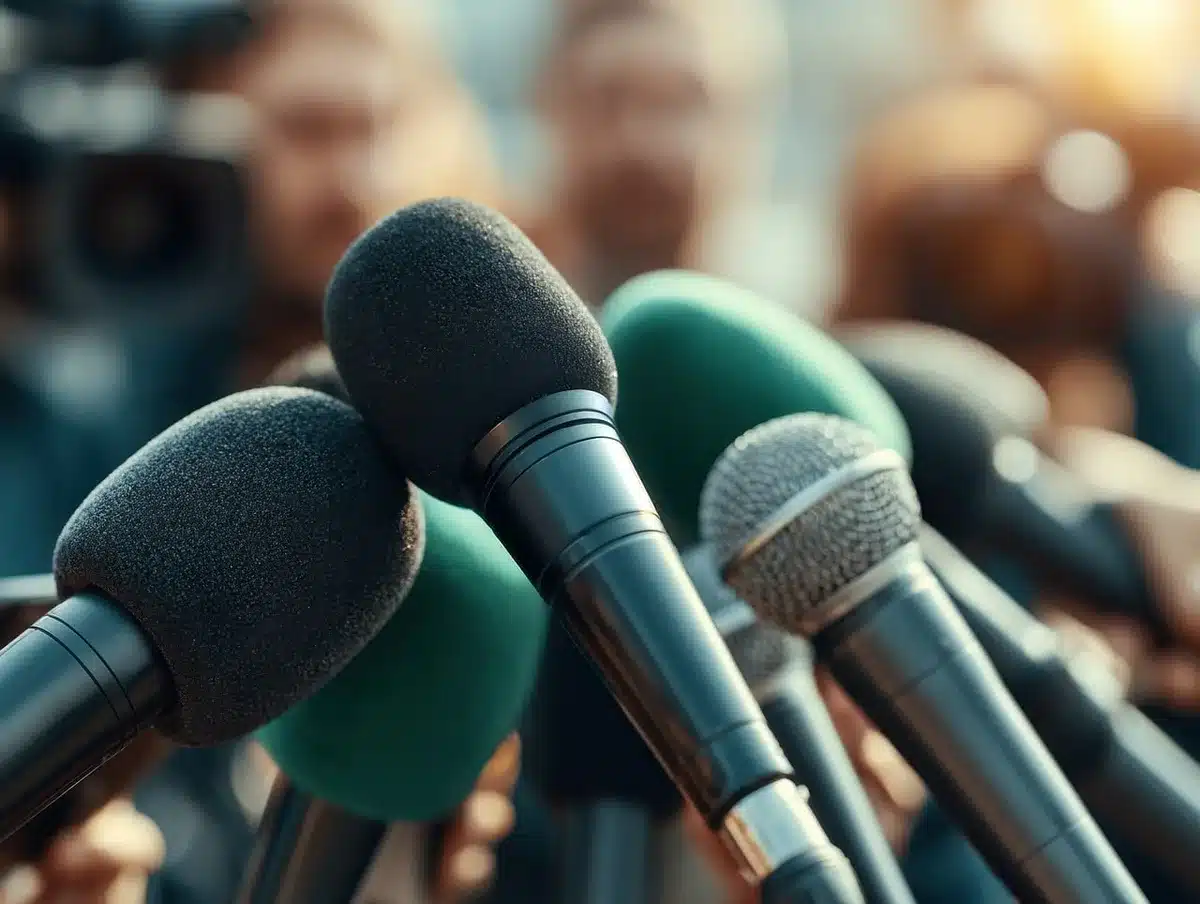 Giornalisti e reporter durante una conferenza stampa con microfoni e telecamere