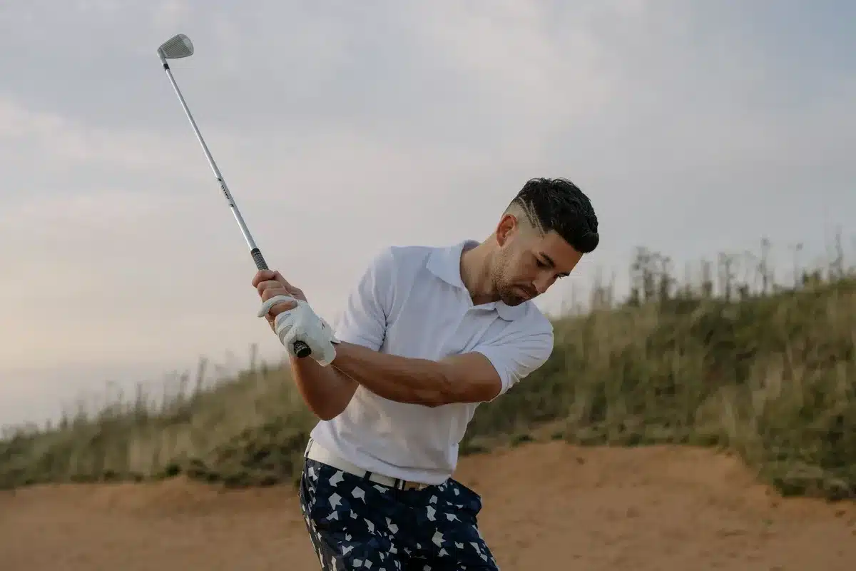 Actor portraying a golfer with exaggerated facial expression during a swing