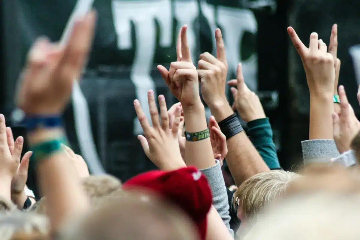 Concert audience with hands raised showing enthusiasm and support