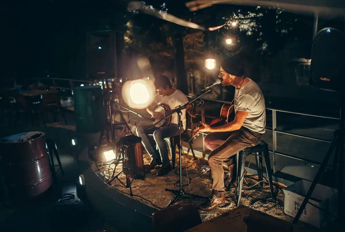 Musician performing on stage with protective support, concert lighting in background