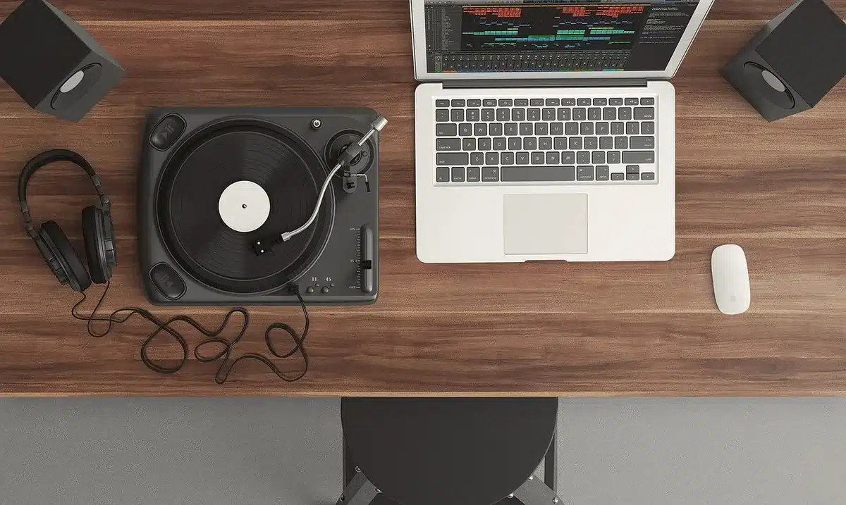 Producer editing a looped sample on a laptop in a home studio