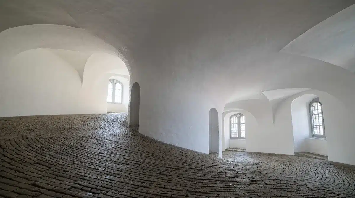Long empty hallway lined with doors and humming lights