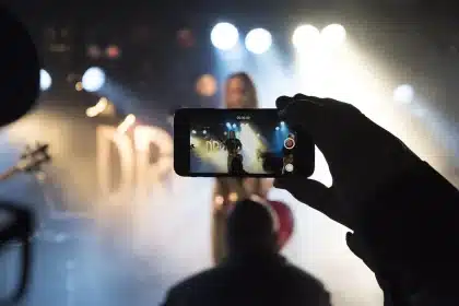 Smartphone playing a short social video on a café table with hands and coffee