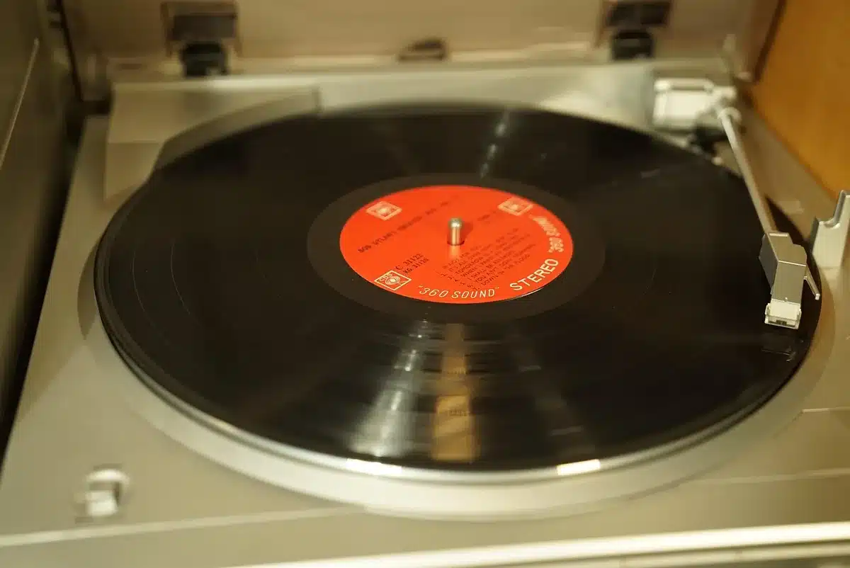 Turntable with vinyl, headphones and handwritten notes on a wooden table