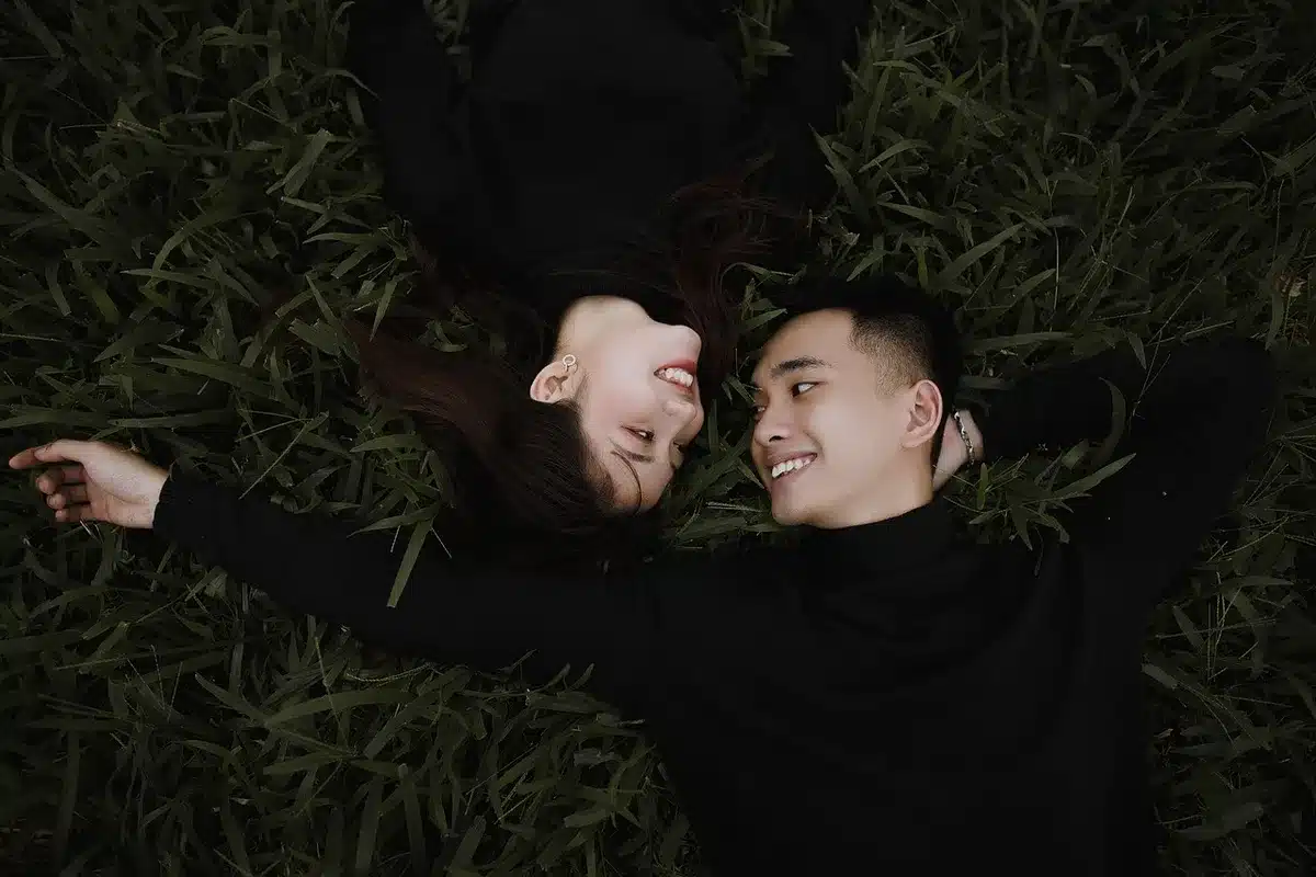 Two people looking at a phone screen together, sharing a music playlist in an intimate moment