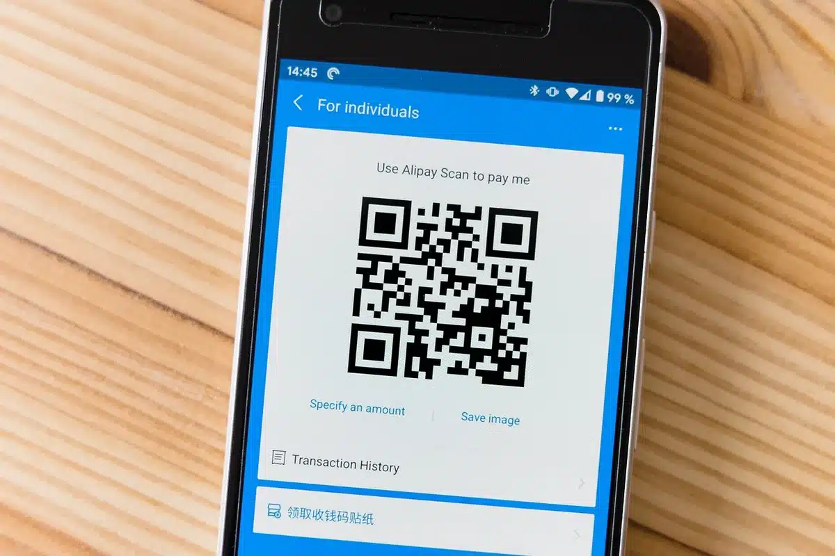Person tapping phone to pay at a card reader for contactless purchase