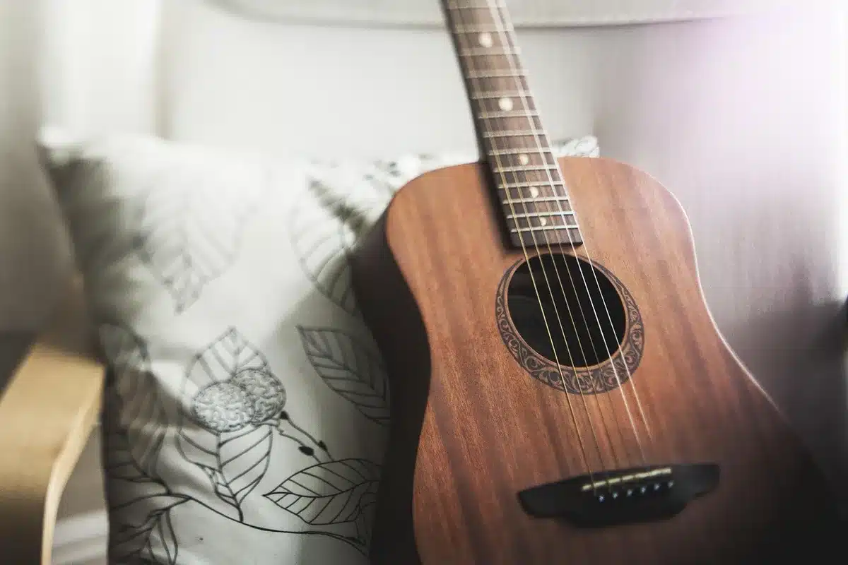 Delicate acoustic guitar and hands playing in soft light