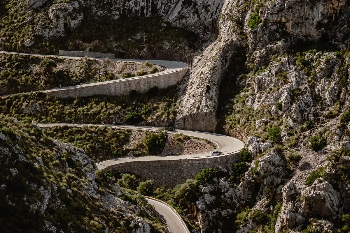 Lonely snow-covered road leading toward distant mountains