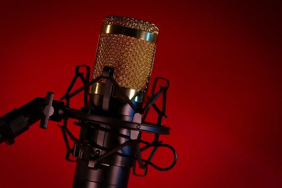 Close-up of a podcast microphone and headphones on a desk