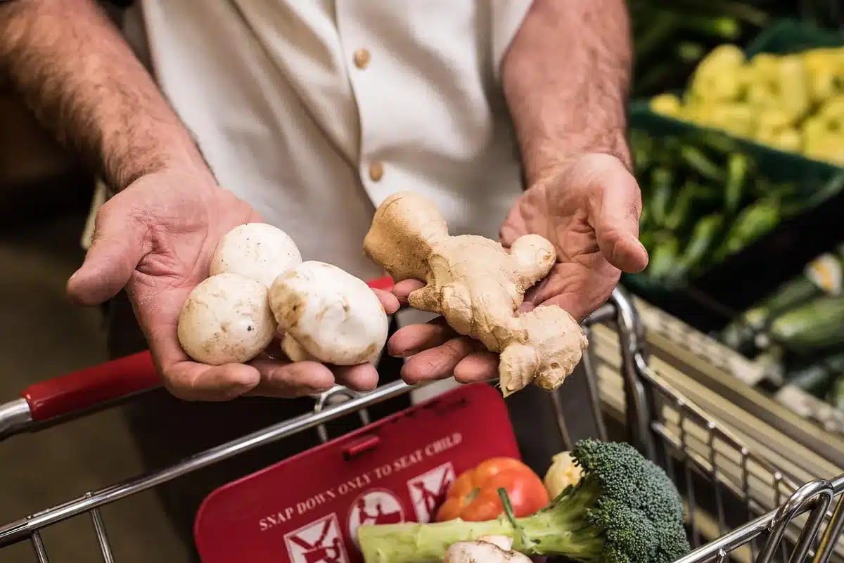 Parent comparing grocery prices while holding a shopping list