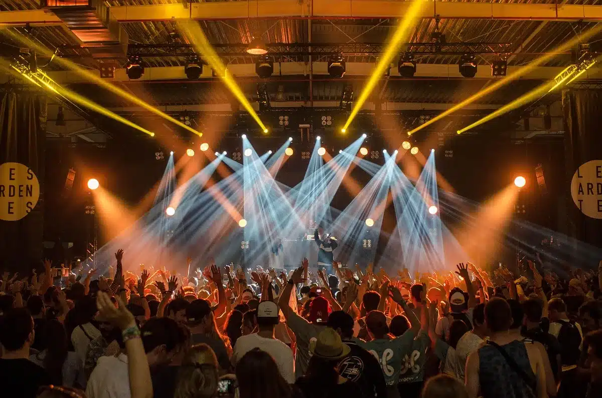 Complex concert stage setup with dramatic multi-colored lighting and technical equipment